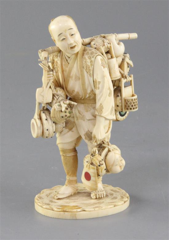 A Japanese inlaid ivory okimono of a street vendor, Meiji period, height 16cm